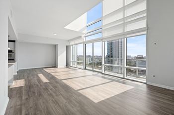 an empty living room with a large window and a view of the city